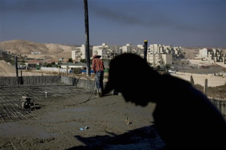 Palestinian men work on a construction site in the West Bank Jewish settlement of Maale Adumim on Sunday. The U.S. has proposed a limit settlement construction.